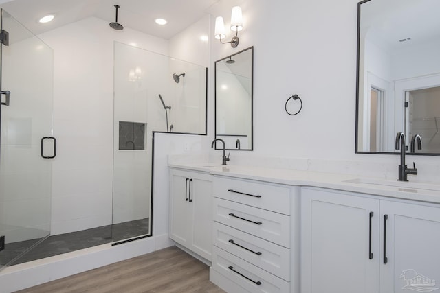 bathroom with hardwood / wood-style flooring, vanity, and a shower with shower door