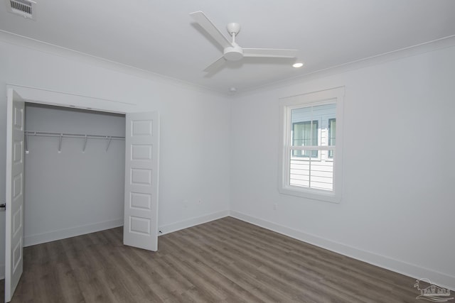 unfurnished bedroom featuring crown molding, dark hardwood / wood-style floors, ceiling fan, and a closet