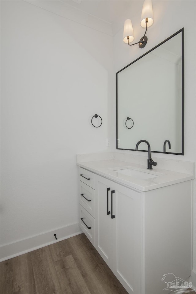 bathroom with vanity, wood-type flooring, and ornamental molding