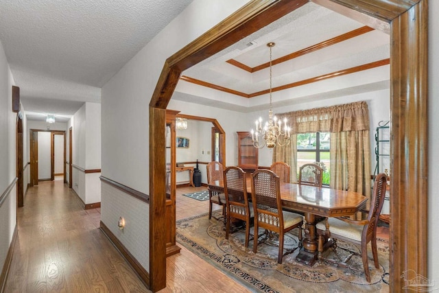 5816 Forest Ridge Dr, Pensacola, FL 32526 - dining space with wood finished floors, a chandelier, baseboards, a textured ceiling, and crown molding