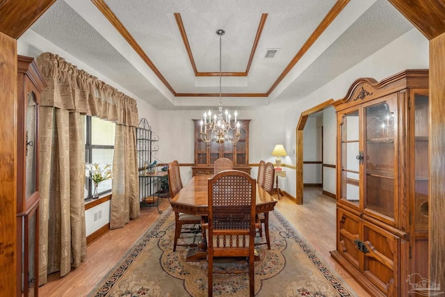 5816 Forest Ridge Dr, Pensacola, FL 32526 - dining room with a tray ceiling, light wood-style flooring, a chandelier, baseboards, and a textured ceiling