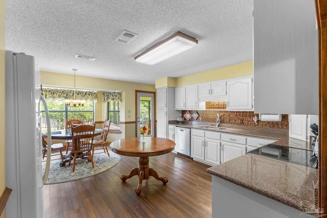 5816 Forest Ridge Dr, Pensacola, FL 32526 - kitchen with stainless steel dishwasher, freestanding refrigerator, a sink, a textured ceiling, and white cabinets