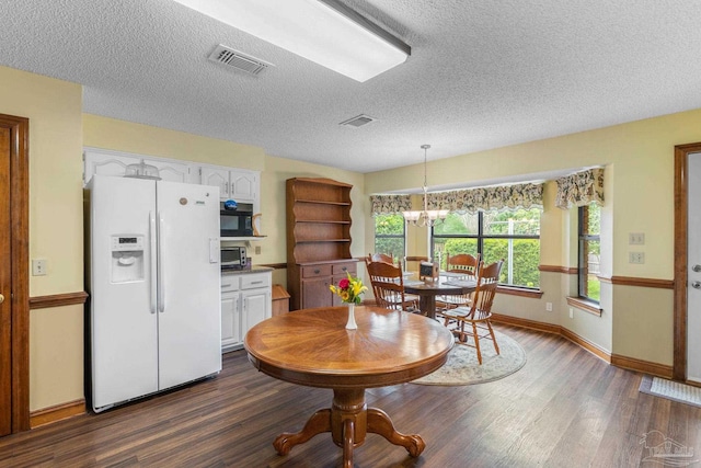 5816 Forest Ridge Dr, Pensacola, FL 32526 - dining area featuring dark wood-style flooring, baseboards, a textured ceiling, and a chandelier