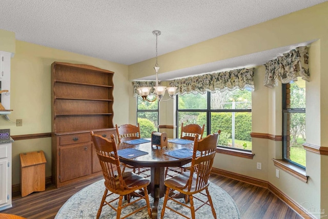 5816 Forest Ridge Dr, Pensacola, FL 32526 - dining space with dark wood finished floors, a chandelier, a textured ceiling, and baseboards