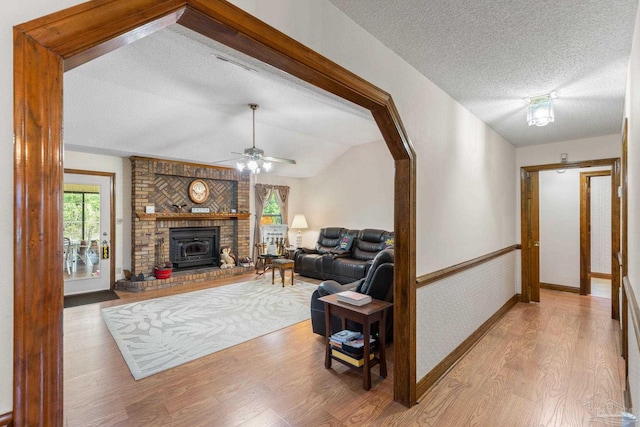 5816 Forest Ridge Dr, Pensacola, FL 32526 - living area with light wood-type flooring, lofted ceiling, a textured ceiling, ceiling fan, and a brick fireplace