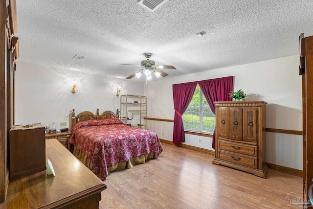 5816 Forest Ridge Dr, Pensacola, FL 32526 - bedroom featuring light wood-style floors, a textured ceiling, baseboards, and ceiling fan