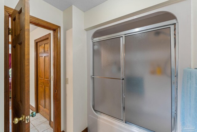 5816 Forest Ridge Dr, Pensacola, FL 32526 - bathroom featuring combined bath / shower with glass door, tile patterned flooring, and a textured ceiling