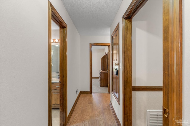 5816 Forest Ridge Dr, Pensacola, FL 32526 - hall featuring light wood-style floors, a textured ceiling, and baseboards