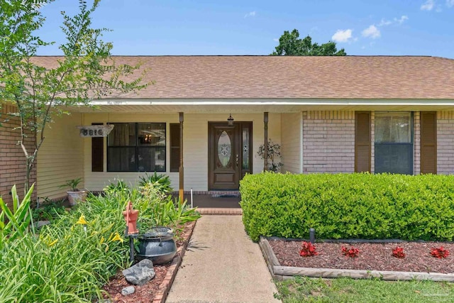 5816 Forest Ridge Dr, Pensacola, FL 32526 - doorway to property featuring covered porch, brick siding, and a shingled roof