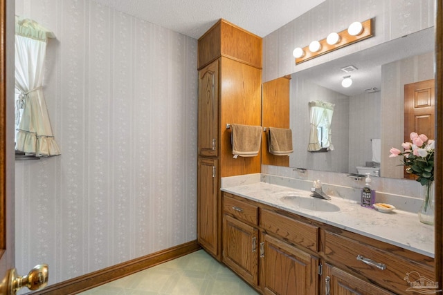 5816 Forest Ridge Dr, Pensacola, FL 32526 - bathroom with wallpapered walls, a textured ceiling, vanity, and toilet