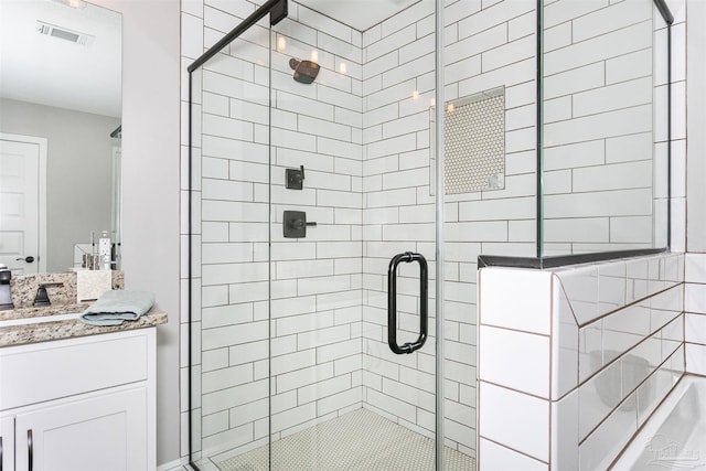 bathroom featuring a stall shower, visible vents, and vanity