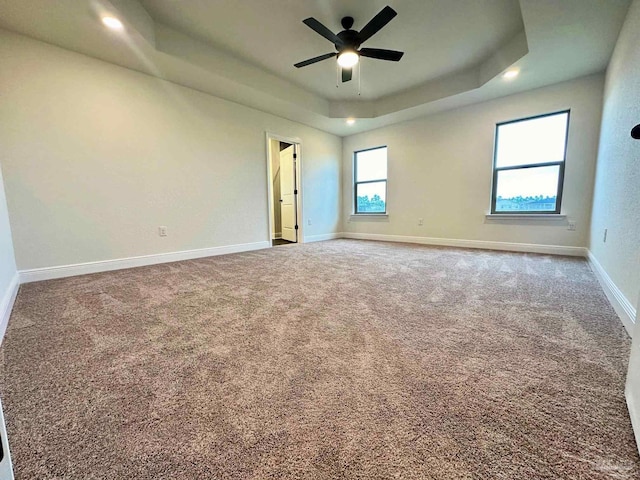 carpeted empty room featuring a tray ceiling, ceiling fan, baseboards, and recessed lighting