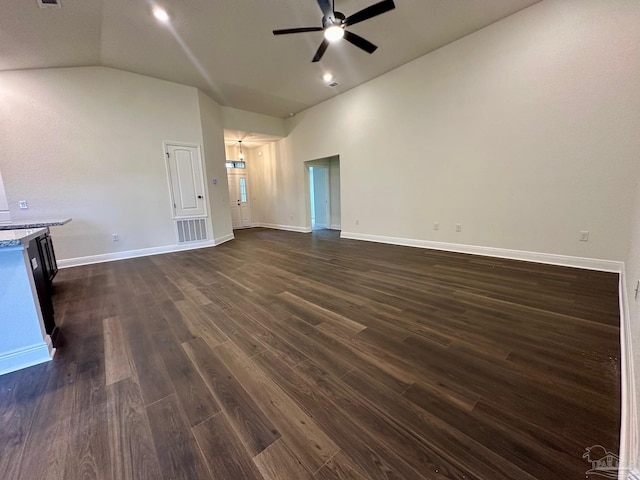 unfurnished living room with ceiling fan, vaulted ceiling, dark wood finished floors, and baseboards