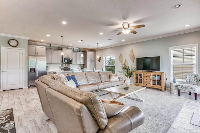 living room with recessed lighting, light wood-style floors, ornamental molding, a ceiling fan, and baseboards