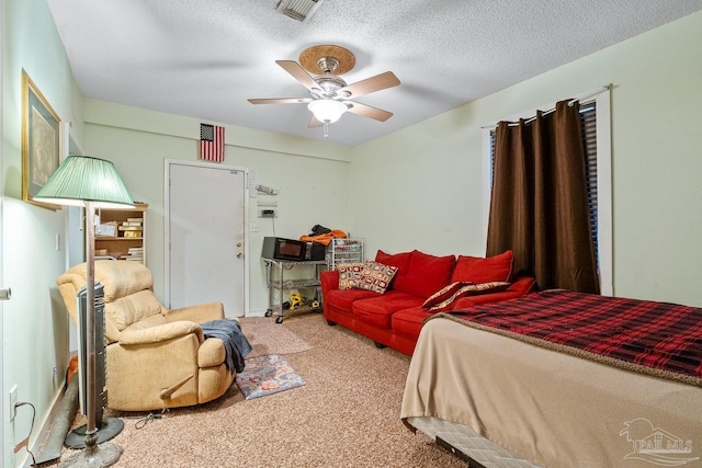 carpeted bedroom featuring visible vents, ceiling fan, and a textured ceiling