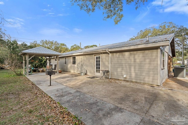 back of property featuring metal roof, a gazebo, a patio area, and central air condition unit