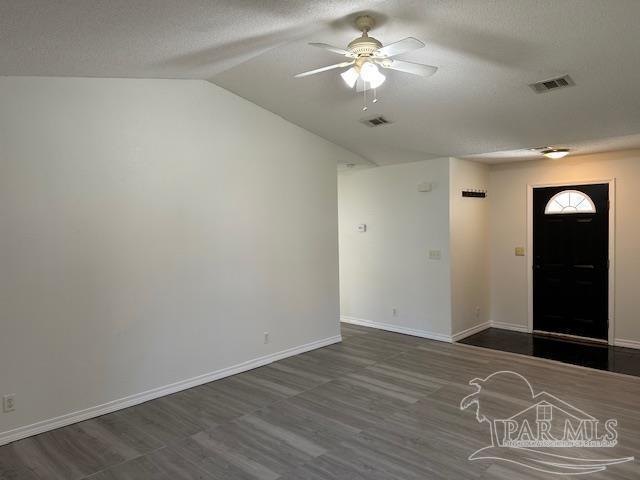 entryway featuring visible vents, baseboards, lofted ceiling, and a ceiling fan