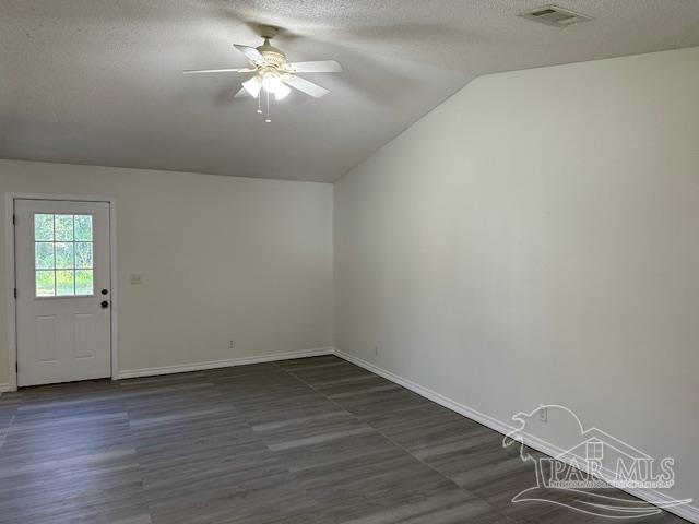 empty room with ceiling fan, vaulted ceiling, visible vents, and a textured ceiling