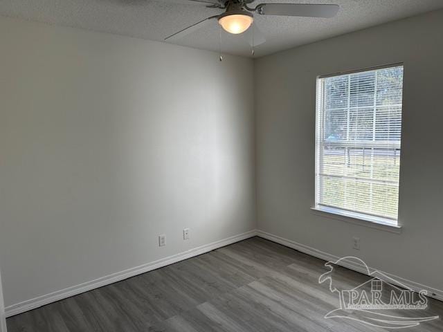 spare room featuring ceiling fan, wood finished floors, baseboards, and a textured ceiling