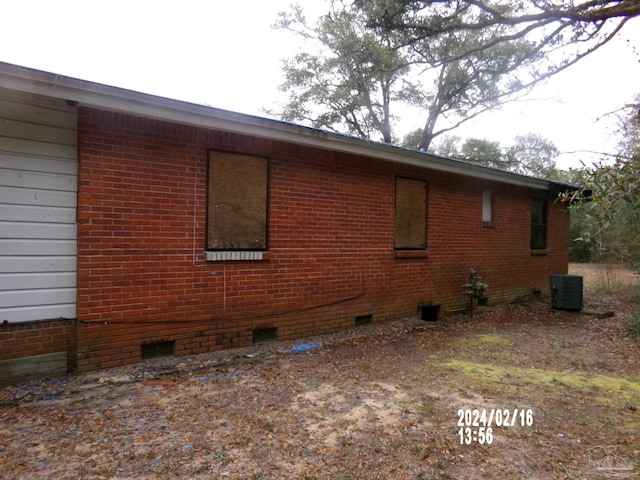 view of property exterior with crawl space, central AC unit, and brick siding