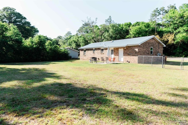 rear view of property featuring brick siding and metal roof