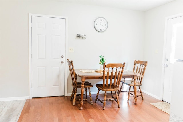 dining space with wood finished floors and baseboards