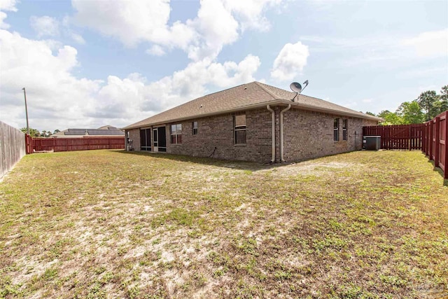 2255 Reed Ridge Ct, Navarre, FL 32566 - back of house with a fenced backyard, central AC unit, brick siding, and a lawn