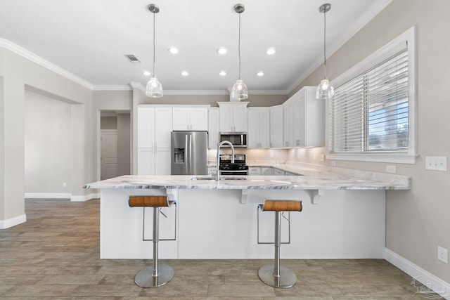 kitchen with pendant lighting, sink, white cabinets, and stainless steel appliances