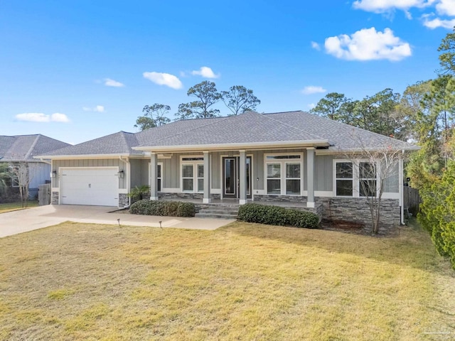 view of front of home with a front yard, a garage, and covered porch