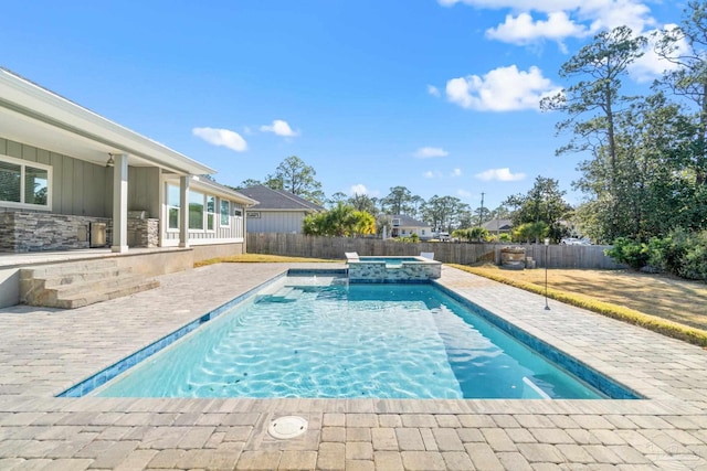 view of swimming pool featuring an in ground hot tub and a patio