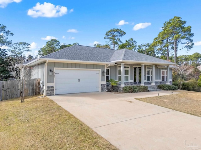 view of front facade featuring a porch, a garage, and a front yard