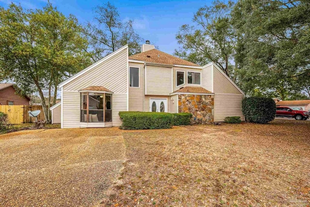 view of front of property with a chimney and fence