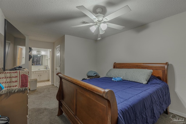 bedroom featuring connected bathroom, a textured ceiling, light colored carpet, and ceiling fan