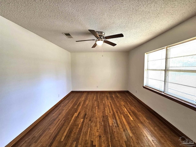 spare room featuring a textured ceiling, ceiling fan, and dark wood-type flooring