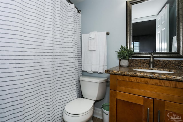 bathroom with toilet, vanity, and a shower with curtain