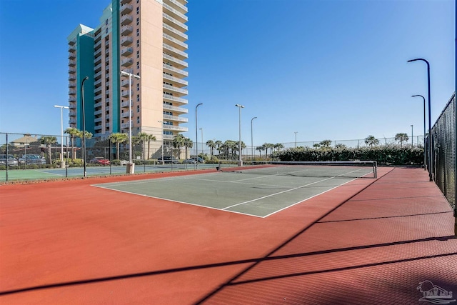 view of tennis court featuring basketball hoop