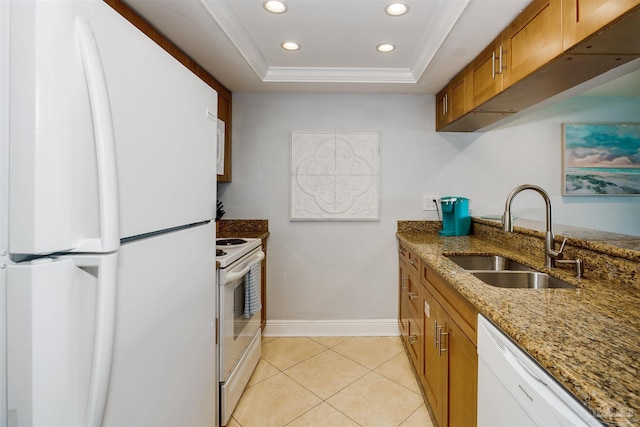 kitchen featuring a tray ceiling, white appliances, crown molding, light stone counters, and sink