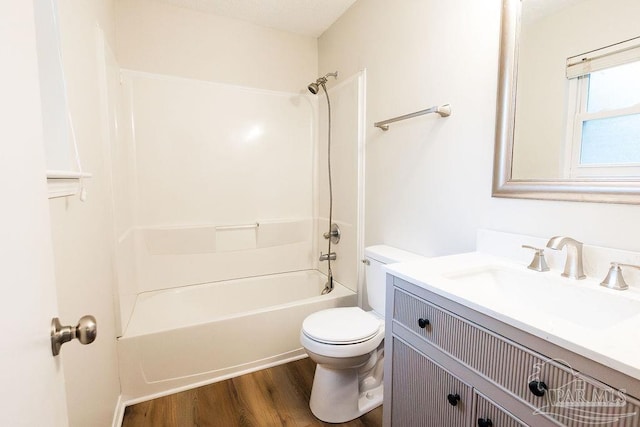 full bath with toilet, shower / bath combination, wood finished floors, and vanity