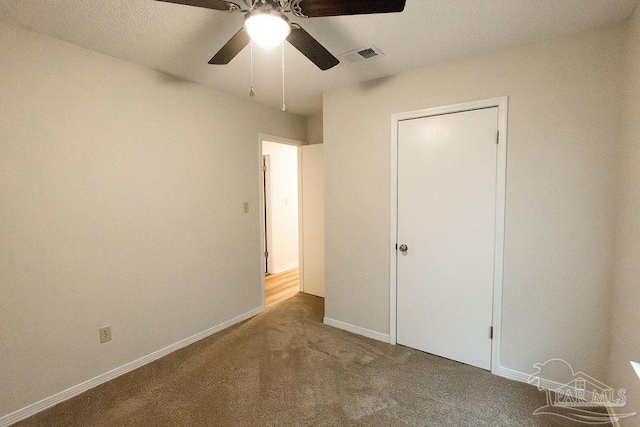 unfurnished bedroom featuring a ceiling fan, baseboards, visible vents, and carpet flooring