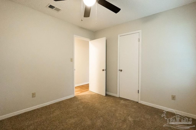 unfurnished bedroom featuring carpet floors, visible vents, ceiling fan, and baseboards