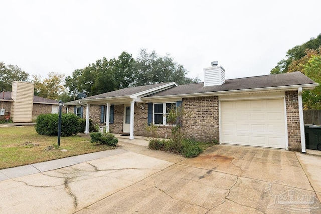 ranch-style house featuring an attached garage, brick siding, driveway, a chimney, and a front yard