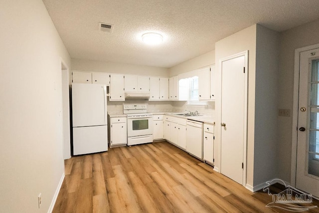 kitchen featuring under cabinet range hood, white appliances, visible vents, white cabinets, and light countertops