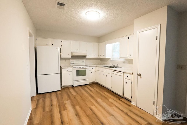 kitchen with light countertops, white appliances, white cabinets, and under cabinet range hood