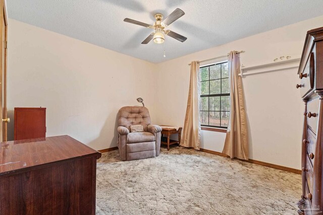 unfurnished room with ceiling fan, light colored carpet, and a textured ceiling