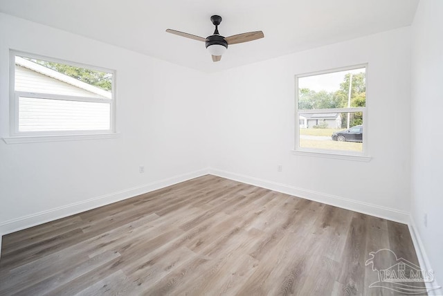 empty room with ceiling fan, plenty of natural light, and light hardwood / wood-style floors