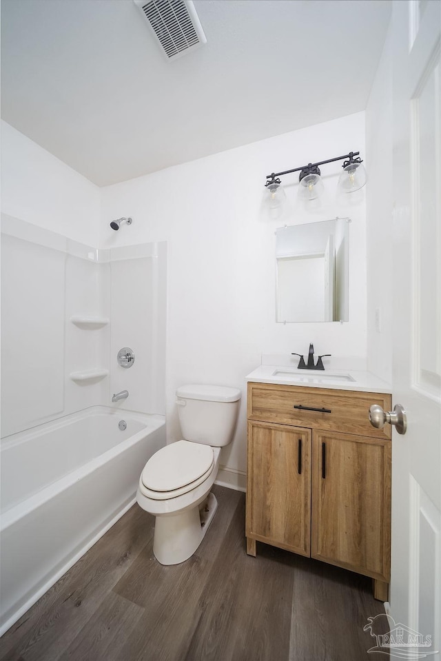 full bathroom featuring wood-type flooring, vanity, shower / tub combination, and toilet