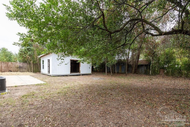 view of yard featuring a shed, a patio area, and central AC unit