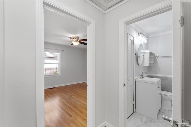 bathroom with wood-type flooring, vanity, ceiling fan, toilet, and crown molding