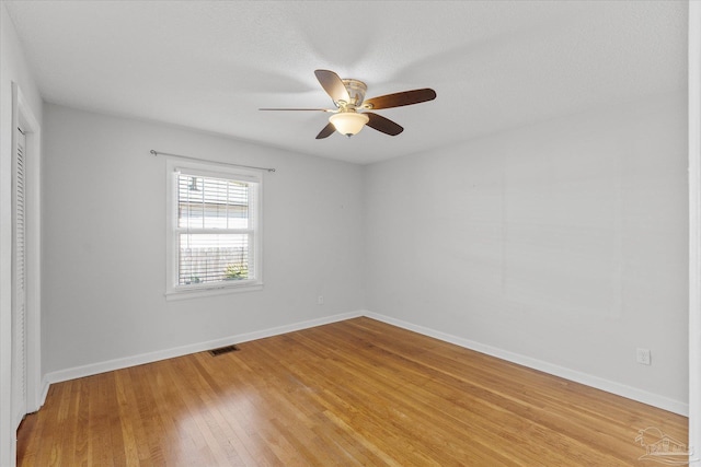 spare room featuring hardwood / wood-style flooring, a textured ceiling, and ceiling fan