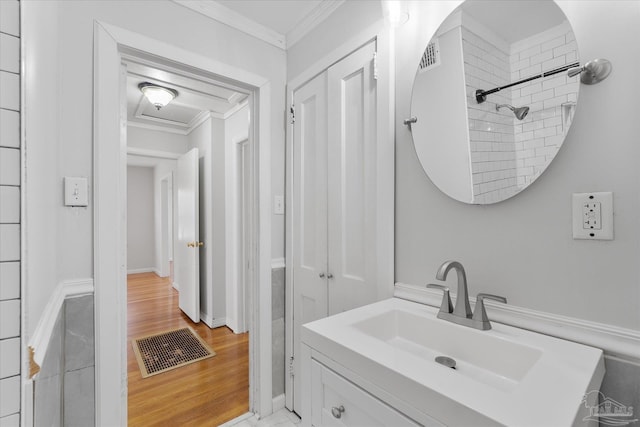 bathroom with crown molding, vanity, hardwood / wood-style floors, and a shower